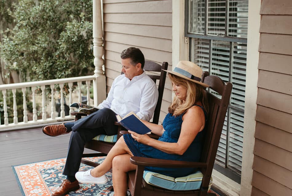 a man and women reading books on the porch